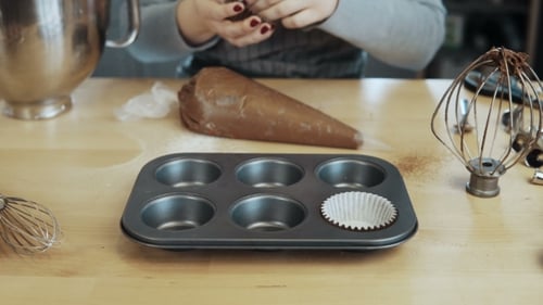 View of Female Hand Putting the Wrappers Paper Cups Into the Baking Tray Woman Cooking Cupcakes