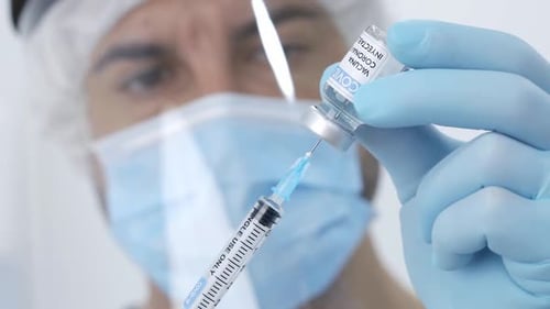 Crop doctor filling syringe with drug in hospital