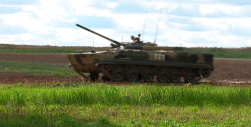 Military Tank Driving Through Rural Grassy Landscape
