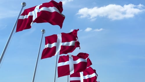 Waving Danish Flags Against Blue Sky