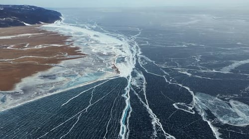 Aerial Perspective View of Beautiful Deep Blue Ice Textured Frozen Baikal Lake Surface and Coast