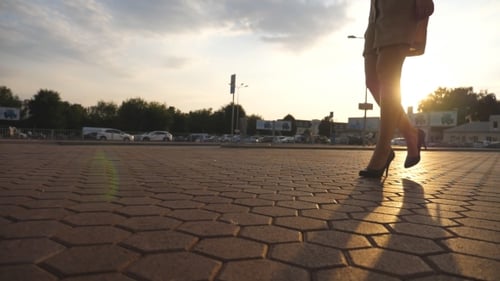 Female Legs in High Heels Shoes Walking in the Urban Street at Sunset. Feet of Young Business Woman