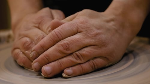 Hands Shaping Clay on Pottery Wheel Close Up