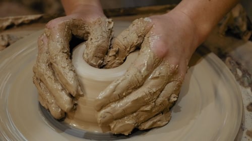 Potter's Hands Shaping Clay on a Wheel