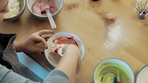 Young Blonde Woman Mixing the Cream for Decorating and Dye in the Bowl Female Cooking