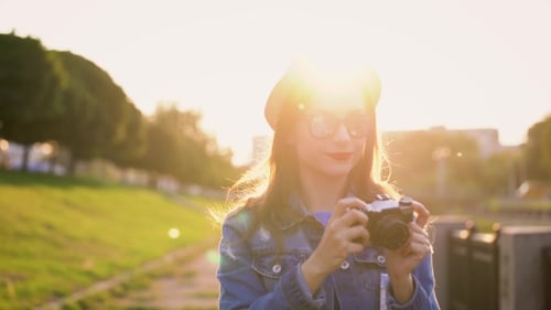 Girl Is Walking Around the City and Taking Photos of Nature and Sights on a Film Camera