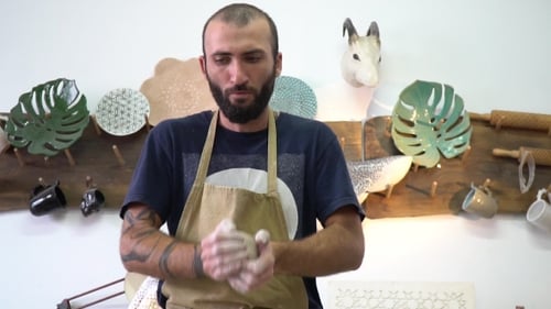 Bearded Potter Shaping Clay in Bright Workshop