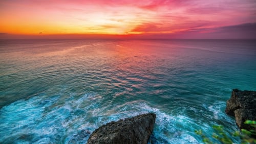 The Incredible Sunset Overlooking the Ocean and Rocks on the Island of Bali in Indonesia.