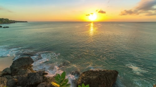of Sunset on the Beach of the Island of Bali in Indonesia, at the Bottom Waves Break Against the