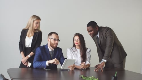 Business Team Collaborating Using Tablet in Modern Office