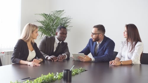 Business Team Discusses Data on Tablet in Meeting