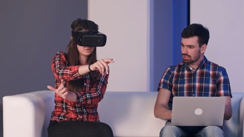 Woman Using Virtual Reality Headset Next to Man