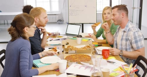 Young People Enjoying Pizza in Office