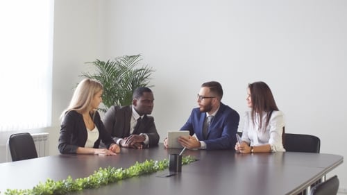 Business Team Discusses Tablet in Modern Office