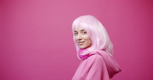 Pretty Young Woman in Wears Tshirt and Pink Hair Looking at Camera