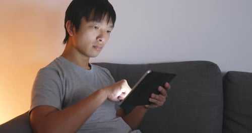 Man use of tablet computer at night