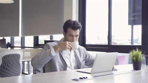 Porträt eines Geschäftsmannes aus dem Nahen Osten, einer Person, die online arbeitet und eine Tasse Kaffee trinkt