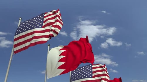 Flags of Bahrain and United States Waving against Blue Sky