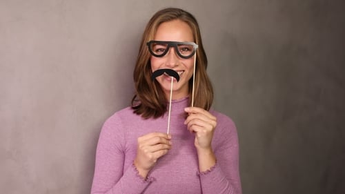 Smiling Woman Holding Party Props, Black Glasses and Moustache
