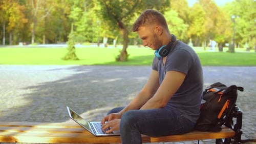 Caucasian Guy Works on Computer at the Open Air