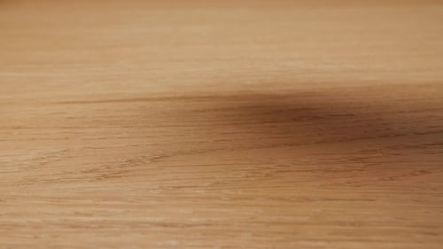 Hand Releases Three Dice onto Wood Table