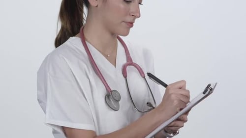 Nurse writing on clipboard turning and nodding