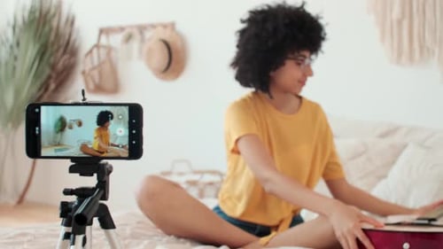 Young Woman Records Herself Playing Guitar