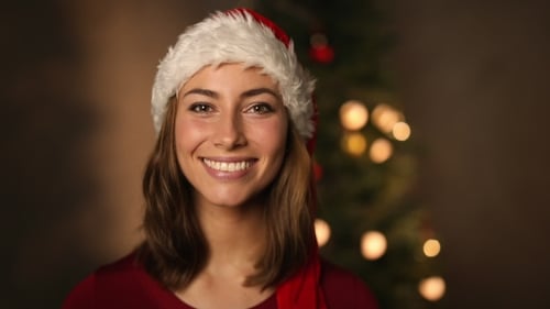 Woman Wearing Santa Hat Smiling at Camera