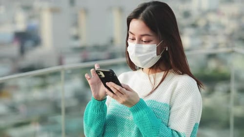 Woman Dances With Smartphone on City Rooftop