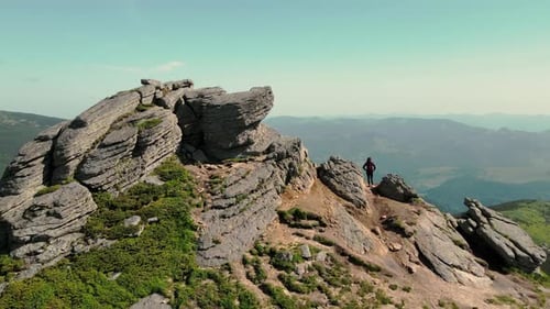 Young Woman Tourist Stands with His Back and Looks at the Beauty of the Mountains