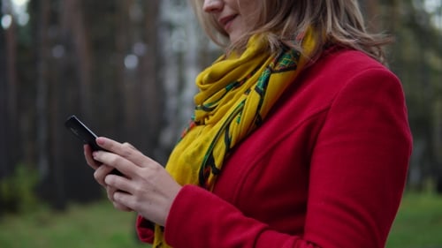 Woman Using Phone Outdoors in Nature