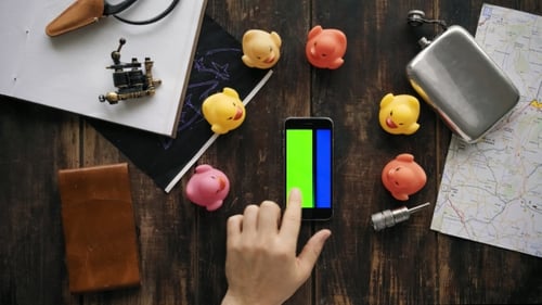 Hand Interacts with Phone Surrounded by Colorful Objects