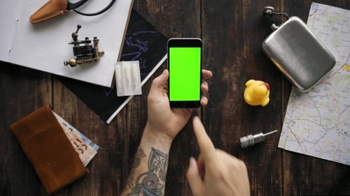 Hand Using Chroma Key Smartphone on Tattoo Table