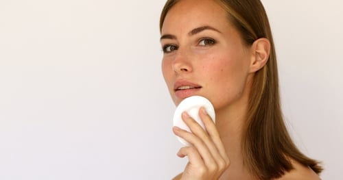 Woman using pressed powder puff