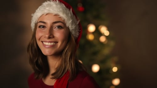 Smiling Woman Wearing Santa Hat Near Christmas Tree