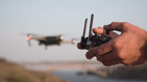 Operating Drone with Controller in Rural Landscape