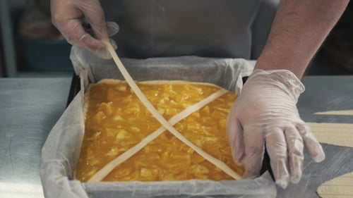 Man Prepares a Fruits Orange Lemon Pie on a Kitchen Table, Final Decoration in Gloves, Restaurant