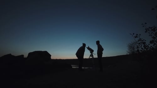 Personas en la costa mirando a través del telescopio