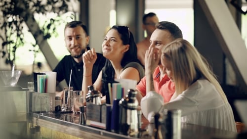 Four Young People in Casual Clothes Are Talking and Laughing Sitting at Bar Counter in Summer Day