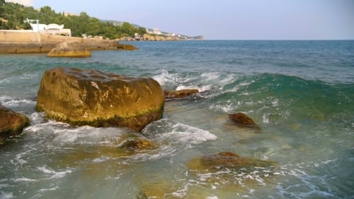 Sea Waves Splashing Against Rocks on Blue Sky