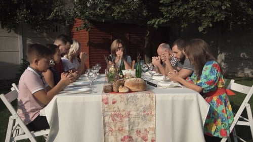 Pessoas orando antes de jantar