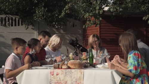 Family Gathering Together Outdoors at Rural Table