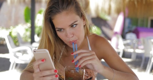 Woman Relaxing with Phone in Resort