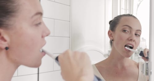 Chica se Pinceles los dientes con cepillo de dientes eléctrico
