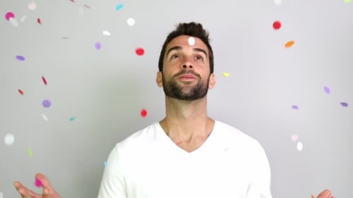 Man Celebrates with Confetti Falling Indoors