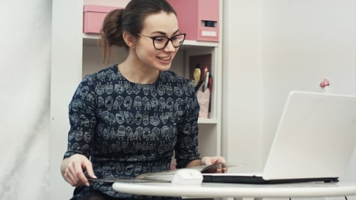 Woman Conversing via Laptop in Home Office