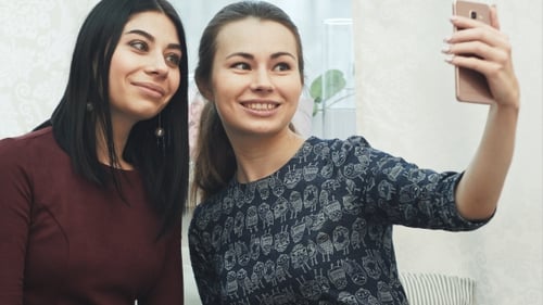 Two Young Women Smiling and Taking a Selfie