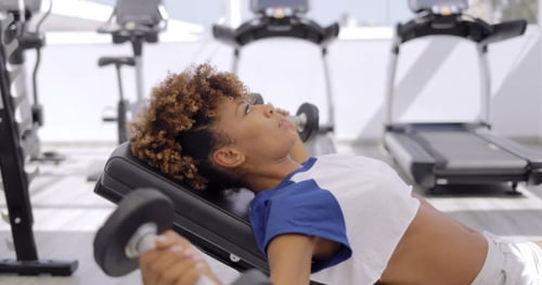 Entrenamiento concentrado de deportista con mancuernas