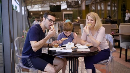 A Happy Family Dines at a Restaurant, a Husband and Wife Ordered a Pizza, Their Little Son Is
