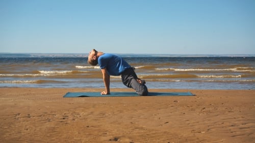 Man Practice Yoga on the Beach at Sunset